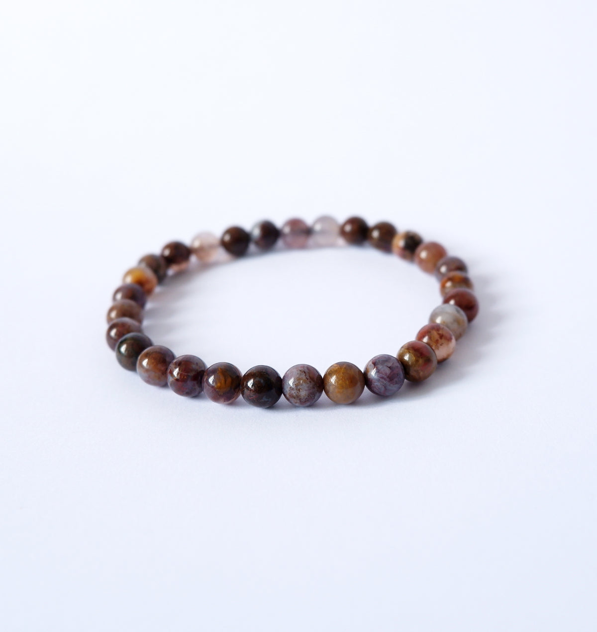 A bracelet made of polished Pietersite crystal beads, strung together with a durable garter, displayed against a white background.