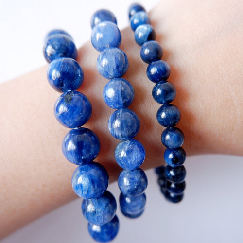 A blue Kyanite bracelet with round beads, displayed on a wrist.